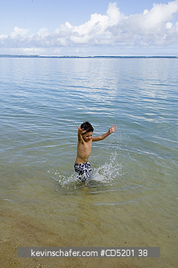 PEOPLE, CHILDREN: Boy, aged 4, playing in ocean, Hawaii