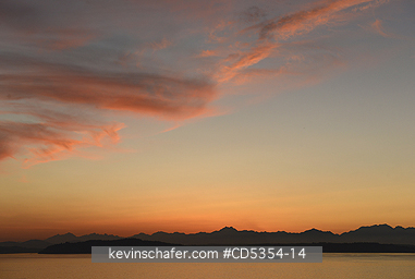 SEATTLE: Ferry crossing Puget Sound at sunset with Olympic Mountains beyond, from West Seattle, Washington